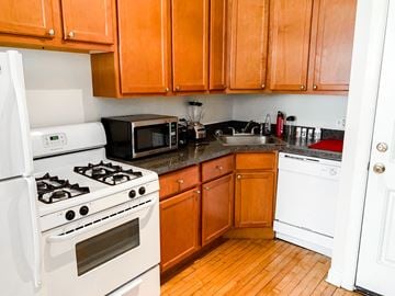 Chicago apartment for rent - A kitchen with wooden cabinets and a white stove.