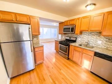 Chicago apartment for rent - a kitchen with stainless steel appliances and wooden cabinets