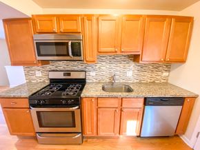 Chicago apartment for rent - a kitchen with wooden cabinets and stainless steel appliances