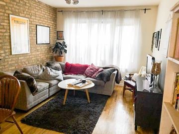 Chicago apartment for rent - A living room with a grey couch and a red throw on it.