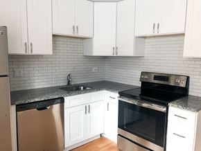 Chicago apartment for rent - A kitchen with white cabinets and a black oven.