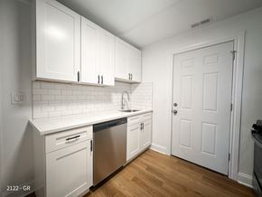 Chicago apartment for rent - A kitchen with white cabinets and a white door.