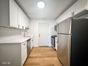 Chicago apartment for rent - A kitchen with white cabinets and a black refrigerator.