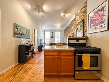 Chicago apartment for rent - A kitchen with a stove top oven and a wooden floor.