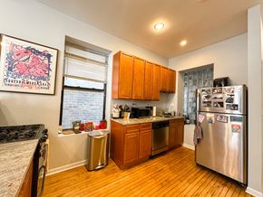 Chicago apartment for rent - A kitchen with wooden cabinets and a fridge.