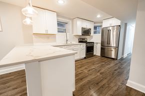 Chicago apartment for rent - A kitchen with white cabinets and a wooden island.