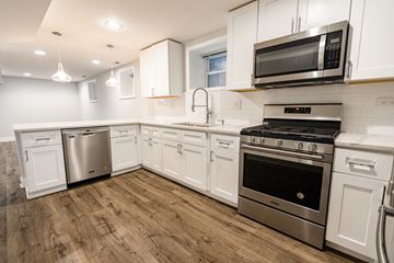 Chicago apartment for rent - A kitchen with white cabinets and stainless steel appliances.