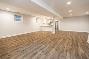 Chicago apartment for rent - A room with wooden flooring and a kitchenette in the background.