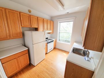 Chicago apartment for rent - A kitchen with wooden cabinets and a white refrigerator.