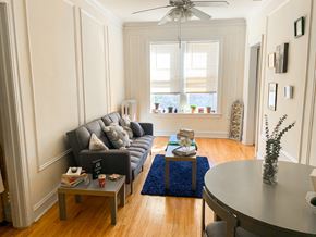 Evanston apartment for rent - A living room with a grey couch, a coffee table, and a ceiling fan.