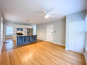 Chicago apartment for rent - A spacious room with wooden floors and a ceiling fan.