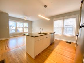 Chicago apartment for rent - A kitchen with wooden floors and a large island.