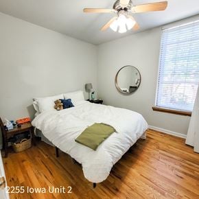 Chicago apartment for rent - A bedroom with a white bed and a ceiling fan.