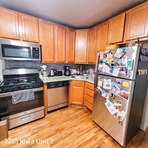 Chicago apartment for rent - A kitchen with wooden cabinets and a fridge covered in photos.
