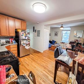 Chicago apartment for rent - A kitchen with a refrigerator, stove, and wooden floors.