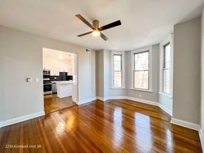Chicago apartment for rent - A spacious room with a ceiling fan and wooden flooring.
