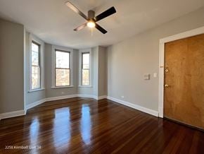 Chicago apartment for rent - A room with a ceiling fan and wooden floors.