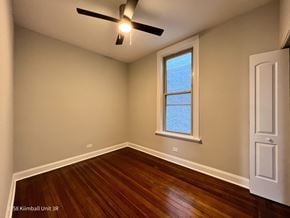 Chicago apartment for rent - A room with a window and a ceiling fan.