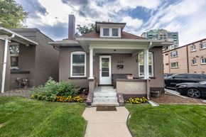 Denver apartment for rent - the front of a brown house with a sidewalk and grass