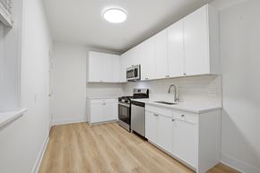 Evanston apartment for rent - A kitchen with white cabinets and a wooden floor.