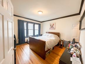 Chicago apartment for rent - A bedroom with a bed, nightstand, and window.