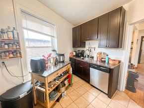 Chicago apartment for rent - A kitchen with a black counter top and wooden cabinets.