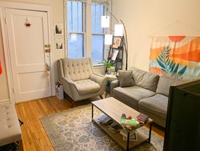 Chicago apartment for rent - A living room with a grey couch, a white chair, and a coffee table.