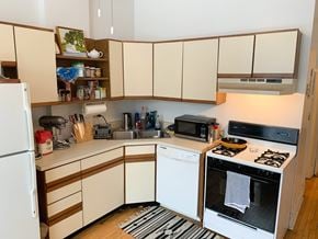 Chicago apartment for rent - A kitchen with white appliances and wooden cabinets.