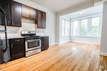 Chicago apartment for rent - A kitchen with black cabinets and wooden floors.