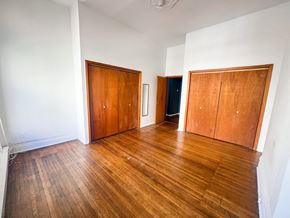Chicago apartment for rent - A room with wooden floors and two wooden doors.
