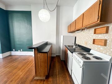 Chicago apartment for rent - A kitchen with a white stove and wooden cabinets.