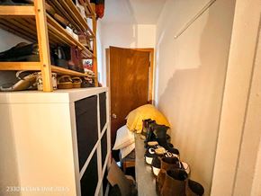 Chicago apartment for rent - A hallway with a yellow blanket and shoes on the floor.