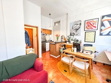 Chicago apartment for rent - A living room with a red couch and a wooden table.