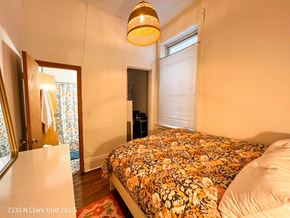 Chicago apartment for rent - A bedroom with a bed covered in a floral print bedspread.