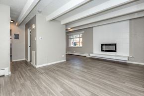 Denver apartment for rent - A spacious living room with a fireplace and a television.