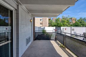 Denver apartment for rent - A balcony with a black railing and a view of a building across the way.