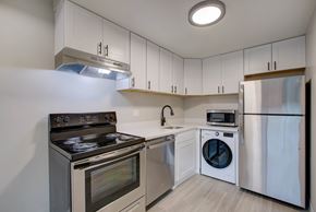 Denver apartment for rent - A modern kitchen with stainless steel appliances and white cabinets.