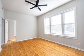 Chicago apartment for rent - A room with a ceiling fan and a window with blinds.