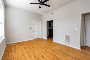Chicago apartment for rent - A room with a ceiling fan and wooden floors.