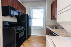 Chicago apartment for rent - A kitchen with black appliances and wooden cabinets.