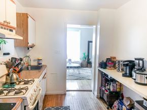 Chicago apartment for rent - A kitchen with a stove top oven and a counter with a coffee maker on it.