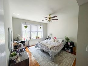 Chicago apartment for rent - A bedroom with a bed, dresser, and ceiling fan.