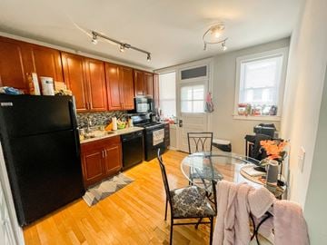 Chicago apartment for rent - A kitchen with wooden cabinets and a black refrigerator.