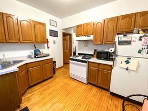 Chicago apartment for rent - A kitchen with wooden cabinets and a white fridge.