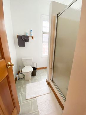 Chicago apartment for rent - A bathroom with a toilet, a trash can, a towel rack, and a rug.