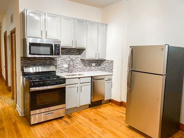 Chicago apartment for rent - A kitchen with a refrigerator, stove, and microwave.