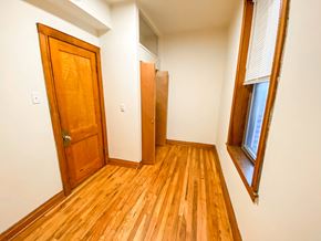 Chicago apartment for rent - A room with a wooden floor and a wooden door.
