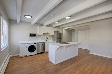 Denver apartment for rent - A kitchen with white cabinets and a wooden floor.