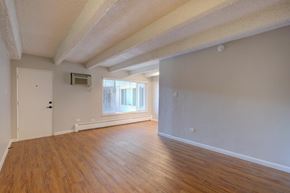 Denver apartment for rent - A room with wooden floors and white walls.
