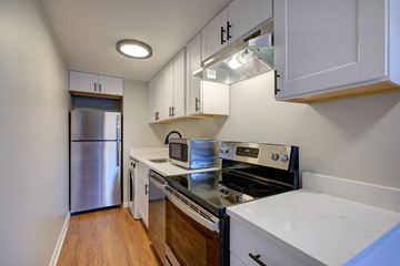 Denver apartment for rent - A kitchen with white cabinets and a stainless steel refrigerator.